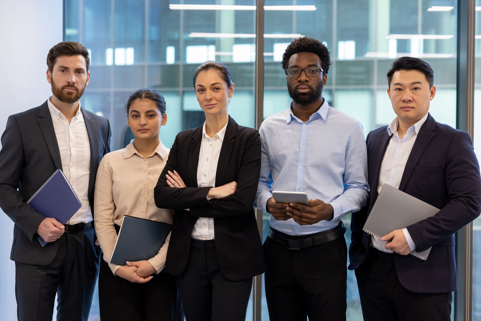 A diverse business team stands together, ready for action in a modern corporate environment.