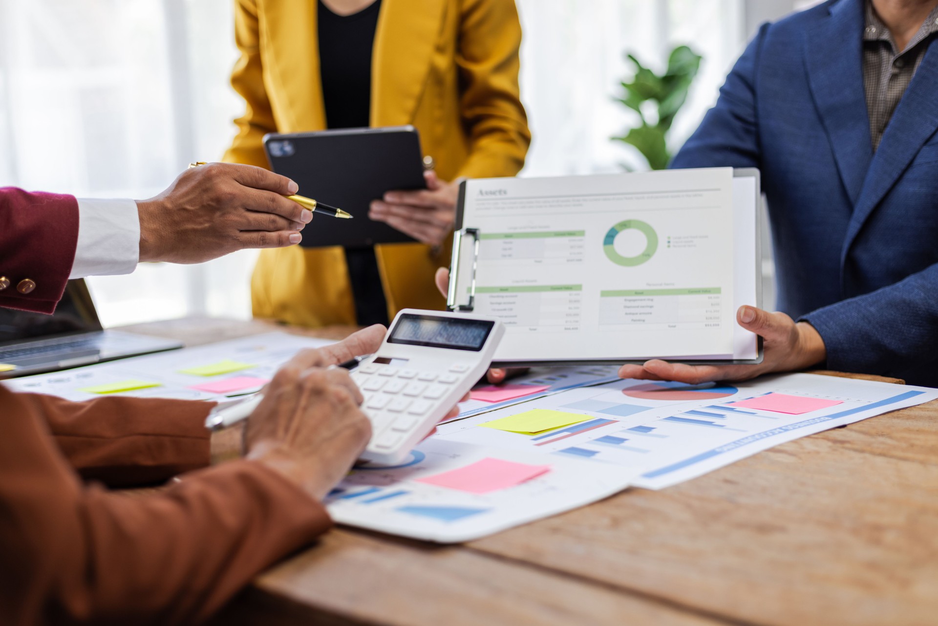Business people analyzing financial statistics working together in office. Business professionals are working together in office, analyzing financial statistics and data on chart and graph.